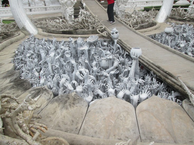 Om de tempel te kunnen bereiken moet je eerst een brug passeren, over een zee van grijpgrage handen. Deze griezelige handen duiden de beproevingen en verleidingen aan die je moet kunnen weerstaan om tot de hemel (Nirvana) te komen.